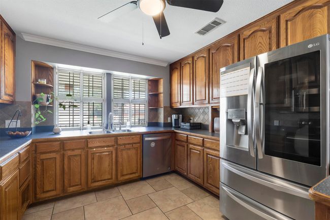 Kitchen featuring appliances with stainless steel finishes, sink, backsplash, and ceiling fan | Image 18