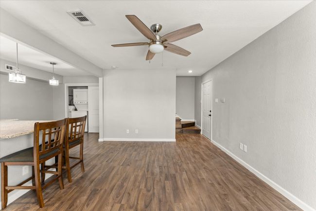 Dining room featuring stacked washer and clothes dryer, dark wood finished floors, ceiling fan, recessed lighting, and stairway | Image 20
