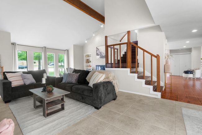 Living room featuring stairway, tile patterned flooring, beam ceiling, high vaulted ceiling, and recessed lighting | Image 28