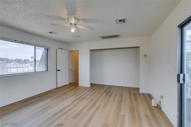 Unfurnished bedroom featuring light wood-style flooring, a textured ceiling, a closet, and ceiling fan | Image 39