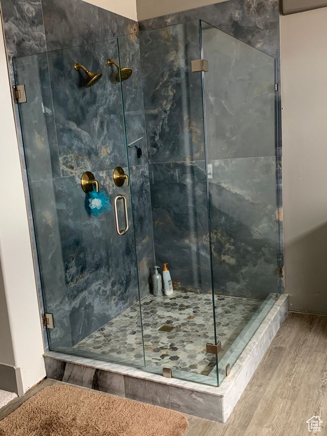 Full bathroom featuring a marble finish shower and wood finished floors | Image 11
