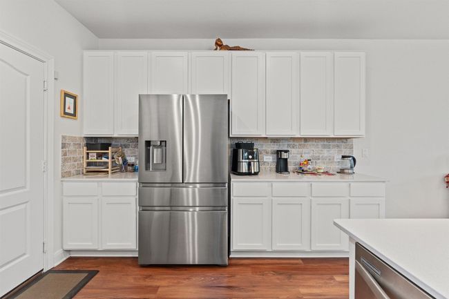 Kitchen with stainless steel appliances, light countertops, and backsplash | Image 12