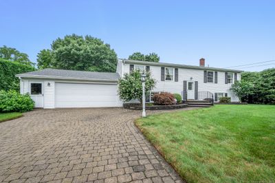 Level lot with lots of great features out front including paver driveway, hard scape flower beds, gutter guards | Image 2