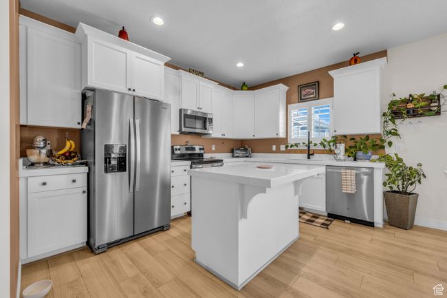Kitchen featuring white cabinets, light wood finished floors, and appliances with stainless steel finishes | Image 8
