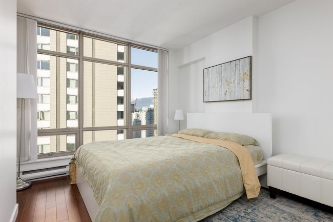 Bedroom with baseboard heating, hardwood / wood-style flooring, and a wall of windows | Image 6