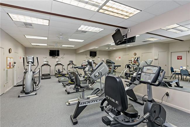 Workout area with ceiling fan, baseboards, and a drop ceiling | Image 9