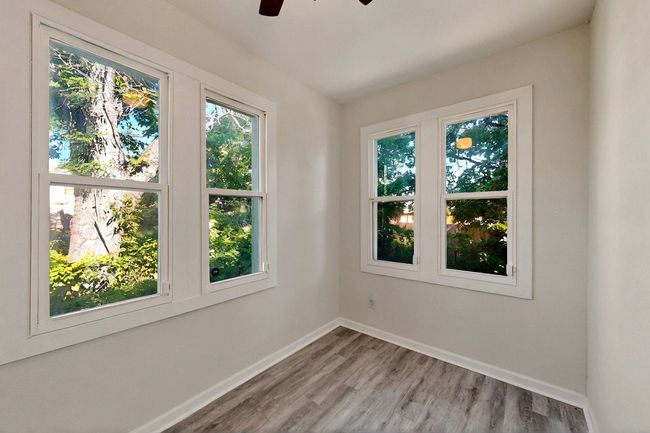 Empty room with ceiling fan, light wood-style floors, and baseboards | Image 12