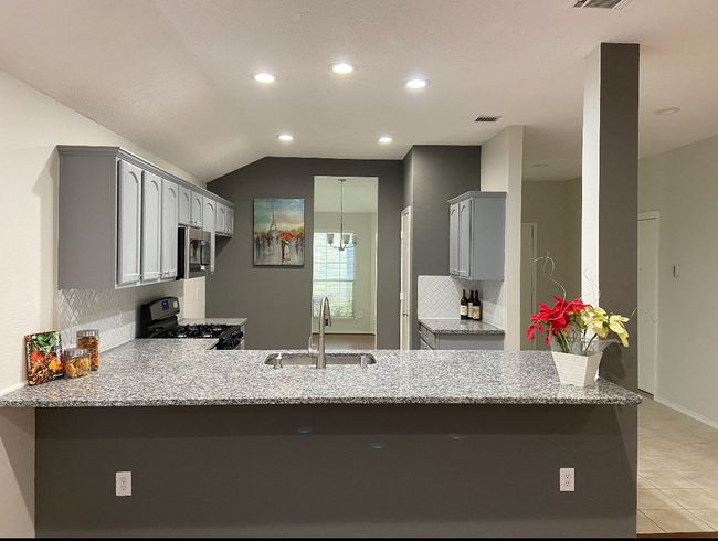 Kitchen with a peninsula, gray cabinetry, recessed lighting, tasteful backsplash, and gas range oven | Image 6