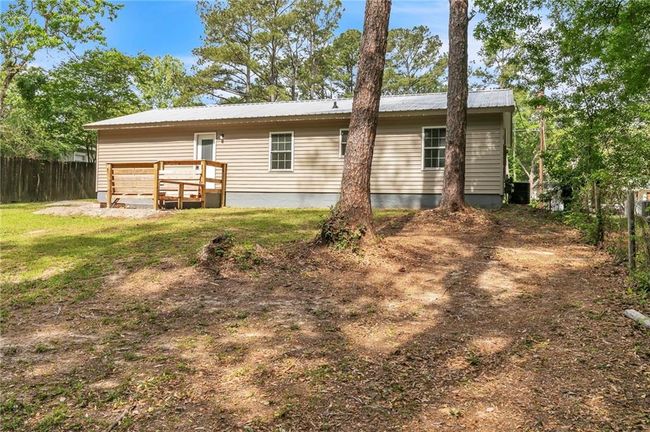 Back of property with fence, a yard, and metal roof | Image 41
