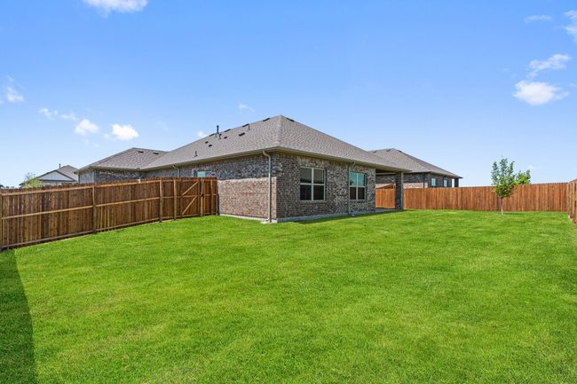 Back of house featuring brick siding, a fenced backyard, and roof with shingles | Image 25