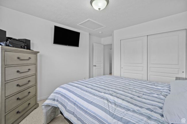 Bedroom with a closet, baseboards, attic access, and light colored carpet | Image 32