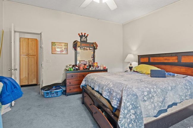 Carpeted bedroom with ceiling fan and ornamental molding | Image 25