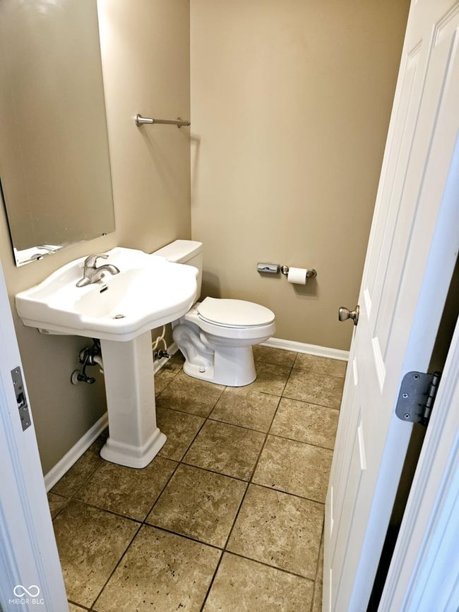 half bath with tile patterned floors, baseboards, and toilet | Image 17