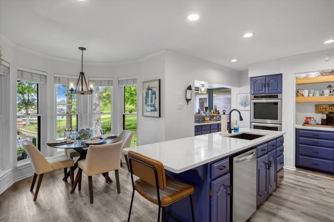 Kitchen with blue cabinets, a healthy amount of sunlight, and a sink | Image 13