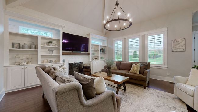 Natural light pours into this stunning living room, highlighting the vaulted ceiling, custom built-ins, shiplap fireplace, and warm, inviting finishes—perfect for cozy nights or bright, cheerful mornings. | Image 24