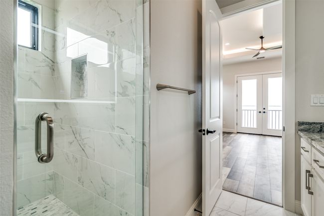 Bathroom featuring a shower with door, french doors, tile flooring, and vanity | Image 20