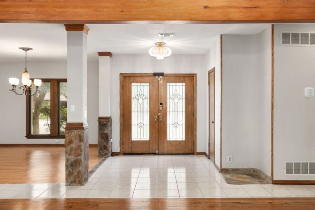 Entrance foyer featuring an inviting chandelier, french doors, and visible vents | Image 9