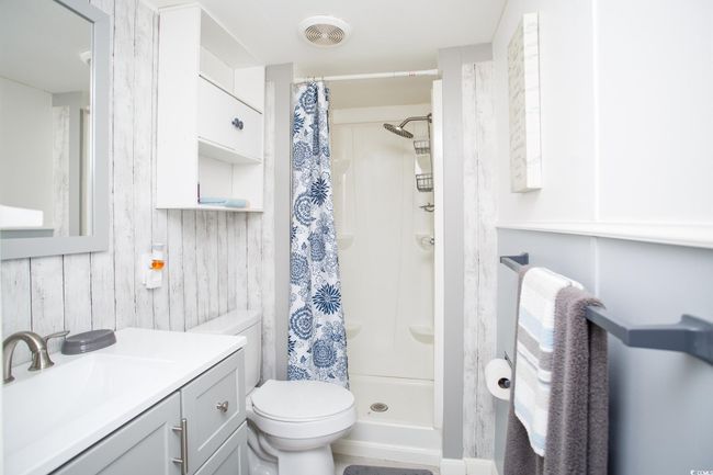 Full bathroom with vanity, toilet, and a shower with curtain | Image 28