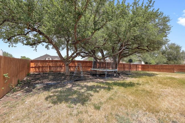 Fenced backyard featuring a trampoline | Image 35