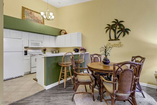 Dining space featuring a chandelier and a towering ceiling | Image 12