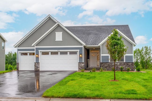 Charming curb appeal welcomes you with a crisp blue-gray facade, white trim, and stone accents. The triple garage and covered entry add both function and warmth. | Image 46