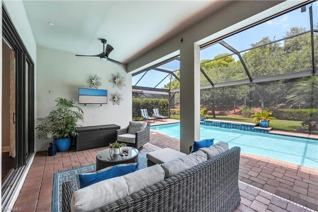 Swimming pool with an outdoor living space, a patio, glass enclosure, and a ceiling fan | Image 6