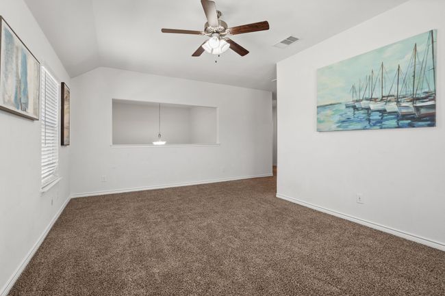 Carpeted Game room featuring a ceiling fan, lofted ceiling, overlooking Entry and baseboards | Image 32