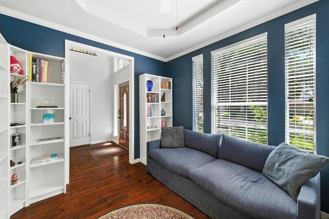 Living area featuring plenty of natural light, wood finished floors, a raised ceiling, and crown molding | Image 14