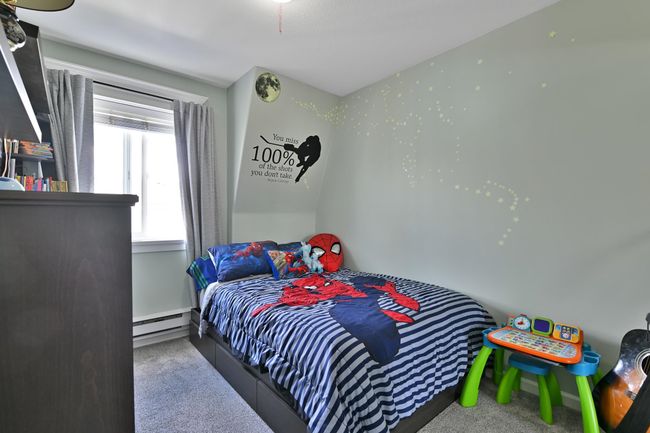 Bedroom featuring a baseboard radiator and carpet | Image 29