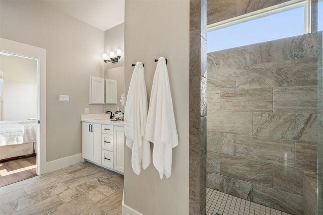 Full bathroom with vanity, walk in shower, baseboards, and ensuite bathroom | Image 15