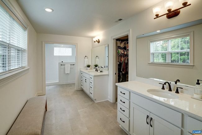 Primary bathroom boasts two separate vanity areas. | Image 32