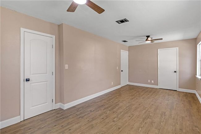 Empty room with visible vents, light wood-type flooring, and baseboards | Image 14