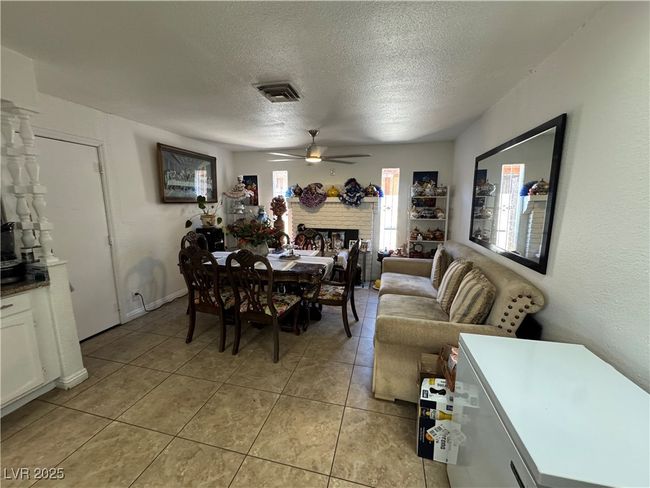 Dining area with a ceiling fan, a textured ceiling, and light tile patterned floors | Image 6