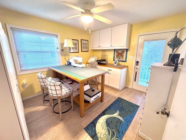 Kitchen featuring light wood-style flooring, white cabinetry, an office area, and a ceiling fan | Image 28