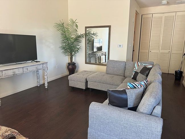 Living room with dark wood-style flooring and baseboards | Image 4