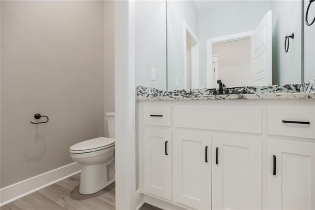 Bathroom with toilet, baseboards, vanity, and wood finished floors | Image 10