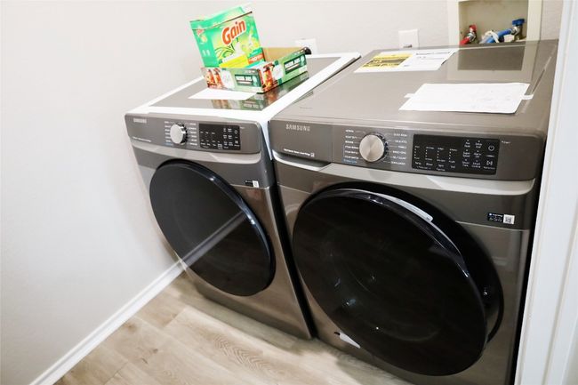 Clothes washing area featuring laundry area, baseboards, separate washer and dryer, and wood finished floors | Image 14