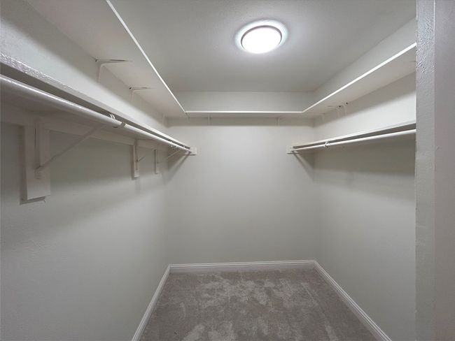 Walk in primary closet with carpet floors | Image 19