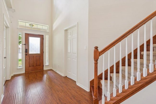Foyer featuring wood finished floors, stairway, and a high ceiling | Image 6