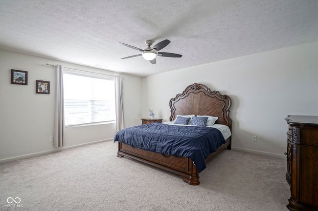 bedroom featuring baseboards, a textured ceiling, carpet flooring, and a ceiling fan | Image 36