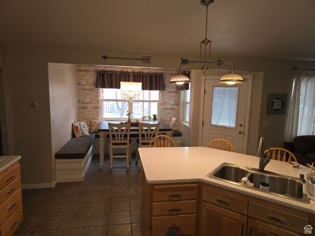 Kitchen featuring a chandelier, light countertops, a sink, and dark tile patterned flooring | Image 23