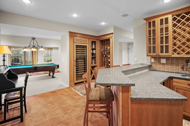 With a built-in wine fridge, extensive bottle storage, and elegant finishes, this lower-level bar is the ultimate gathering spot. | Image 40