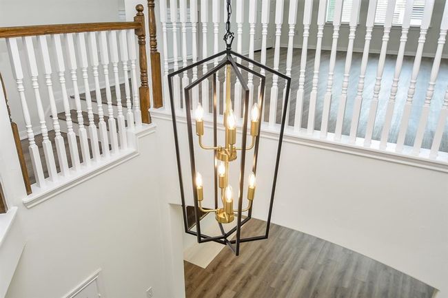 As you make your way upstairs, take a moment to admire the stunning chandelier that adds a touch of elegance and warmth to your home's entryway. | Image 23