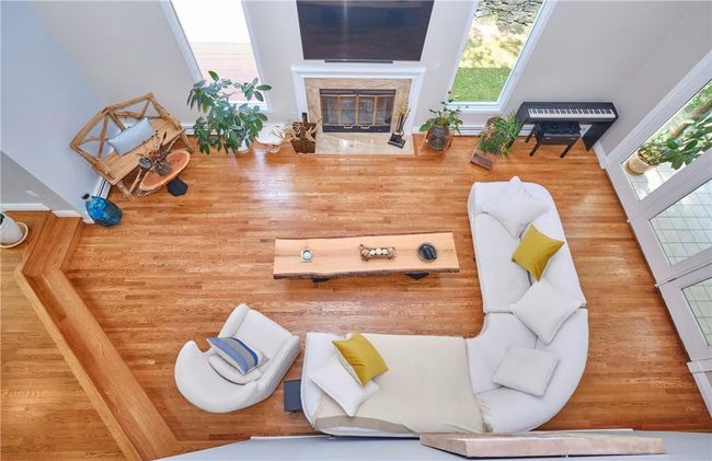 Living room featuring a wealth of natural light, hardwood / wood-style flooring, and a premium fireplace | Image 17