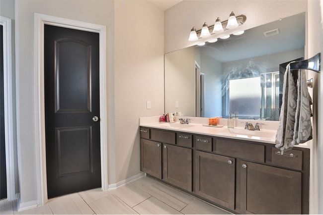 The primary bath features a double vanity, separate tub and shower, and a spacious walk-in closet for added convenience. | Image 17