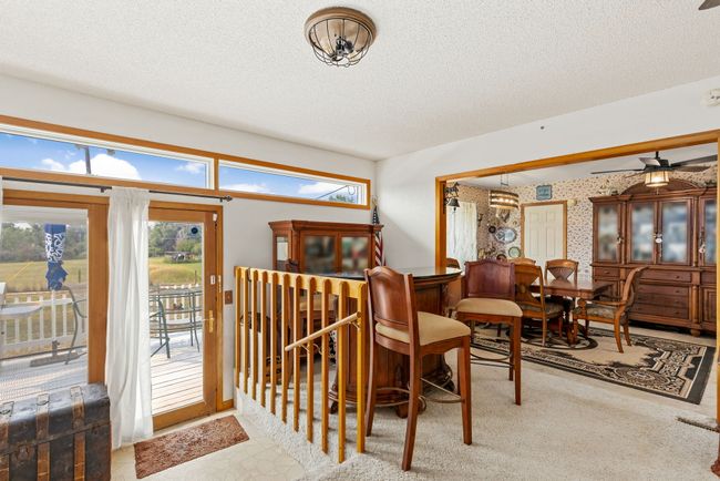 Carpeted dining room with wallpapered walls, a ceiling fan, and a textured ceiling | Image 39