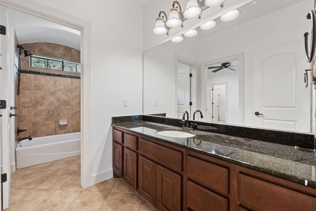 Full bath with vanity, tile patterned flooring, washtub / shower combination, and a ceiling fan | Image 26