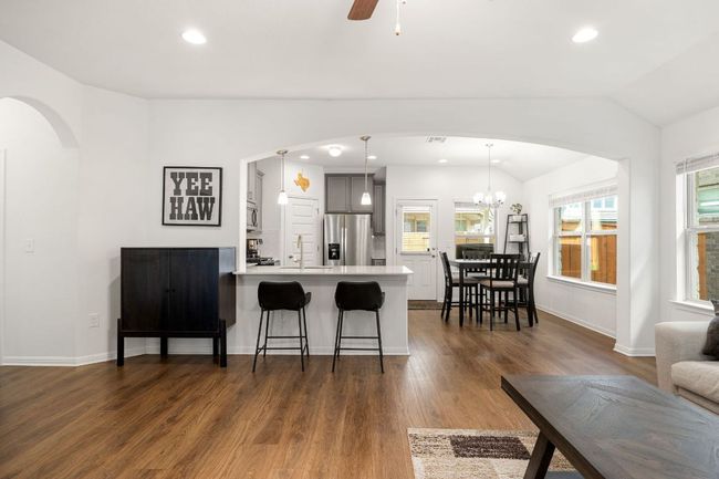 Kitchen featuring arched walkways, a breakfast bar area, light countertops, a peninsula, and lofted ceiling | Image 10