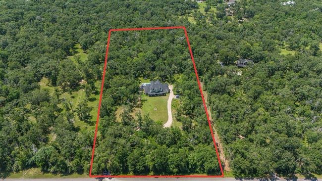Aerial view of the property that sits on 5.3 acres. The area beyond the pool is fenced for containing animals. | Image 45