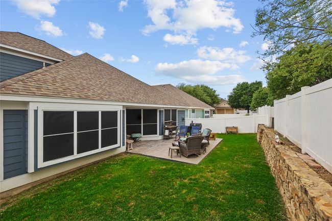 Back of property with a fenced backyard, a shingled roof, and a patio area | Image 33